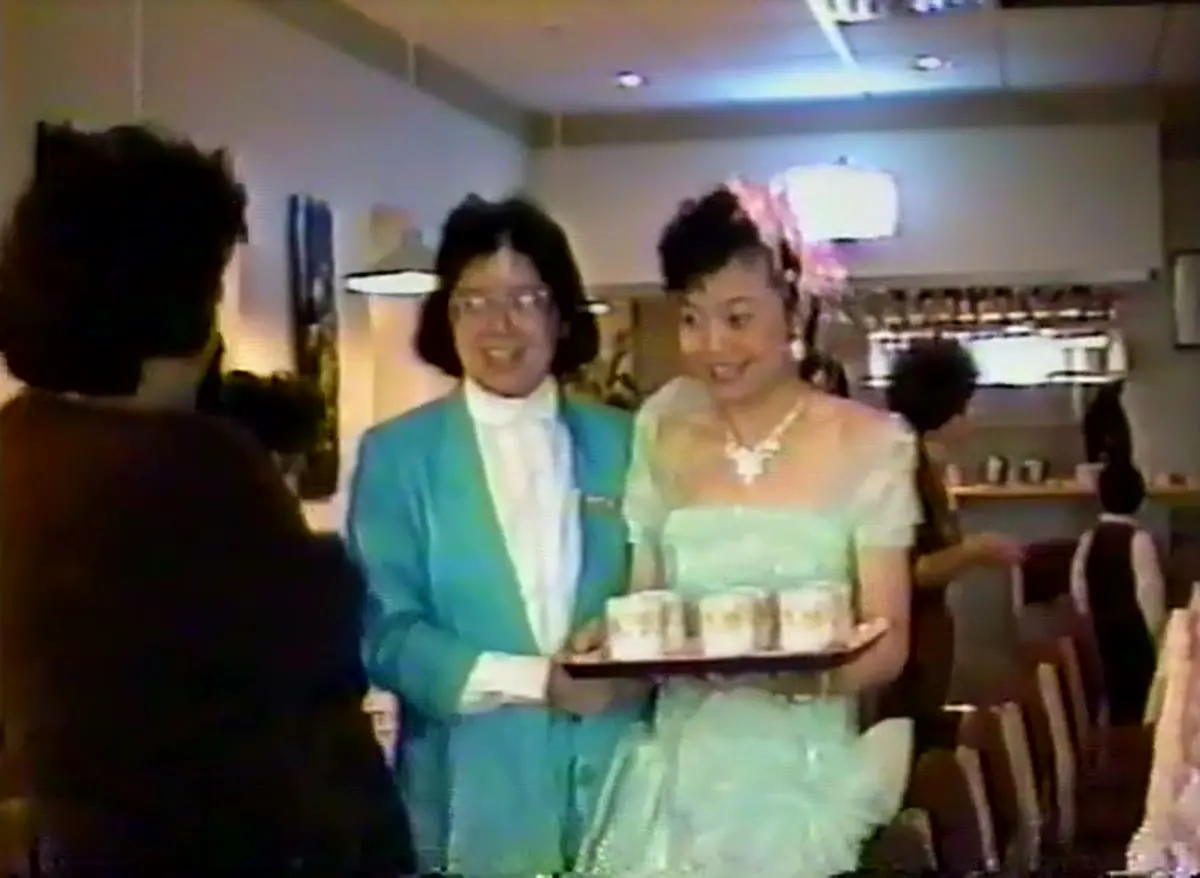 Judy and a family member carrying a tray of tea at her engagement party, 1989