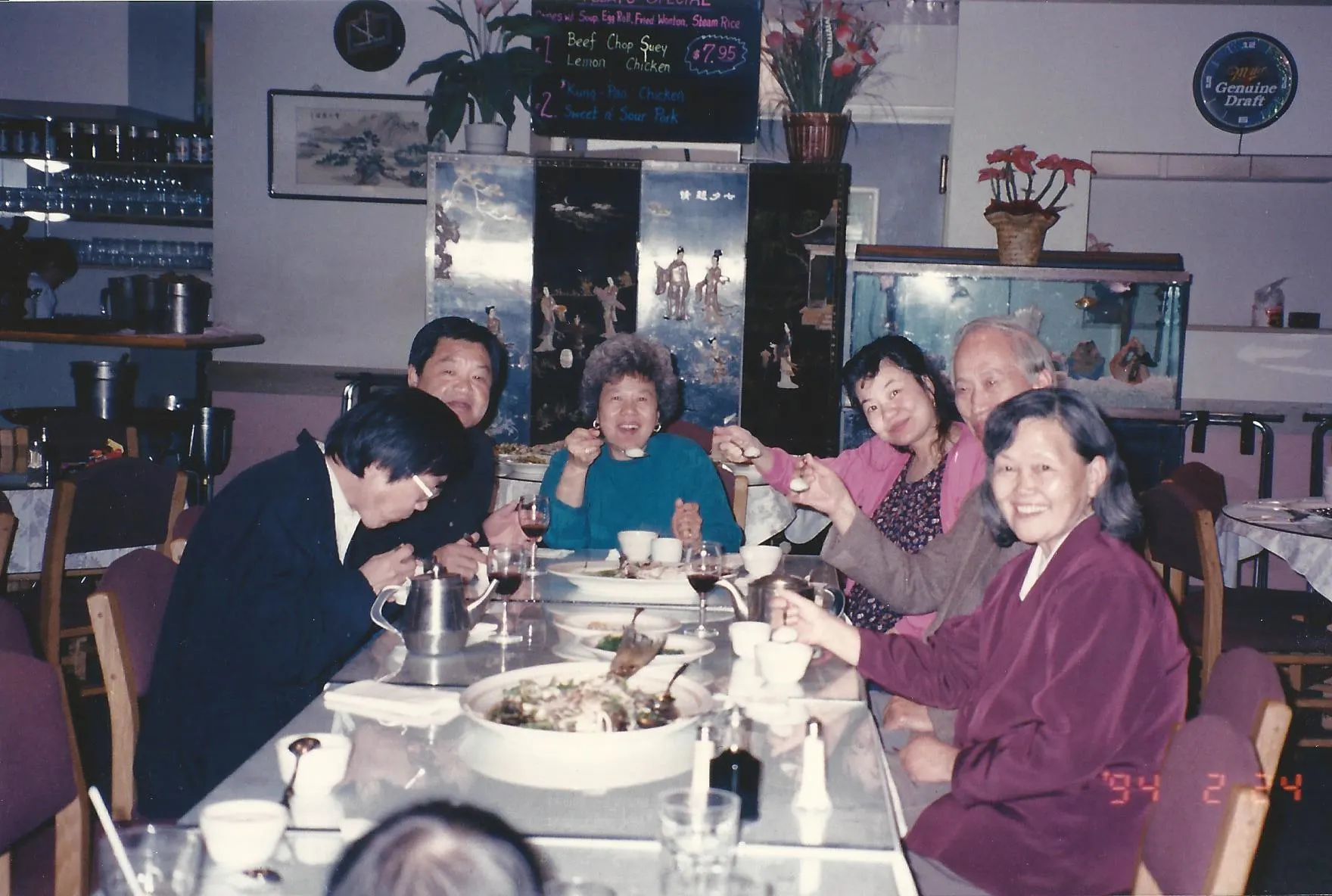 Both sides of the family sharing a family-style meal in the China Dynasty dining room, February 1994