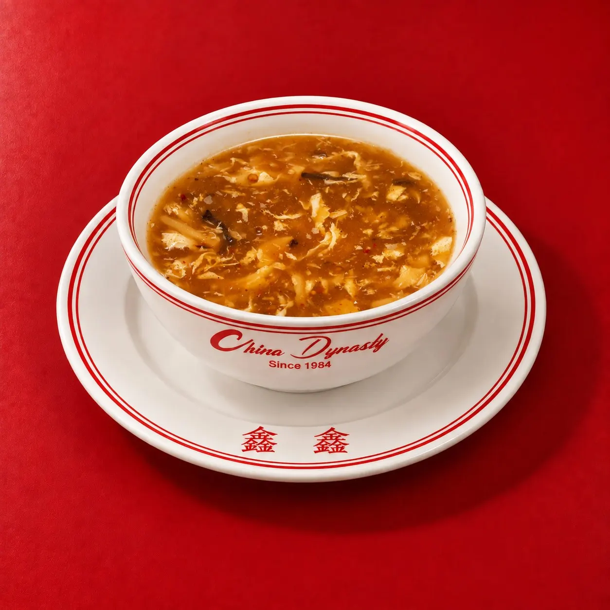 A bowl of China Dynasty hot and sour soup on the branded plate