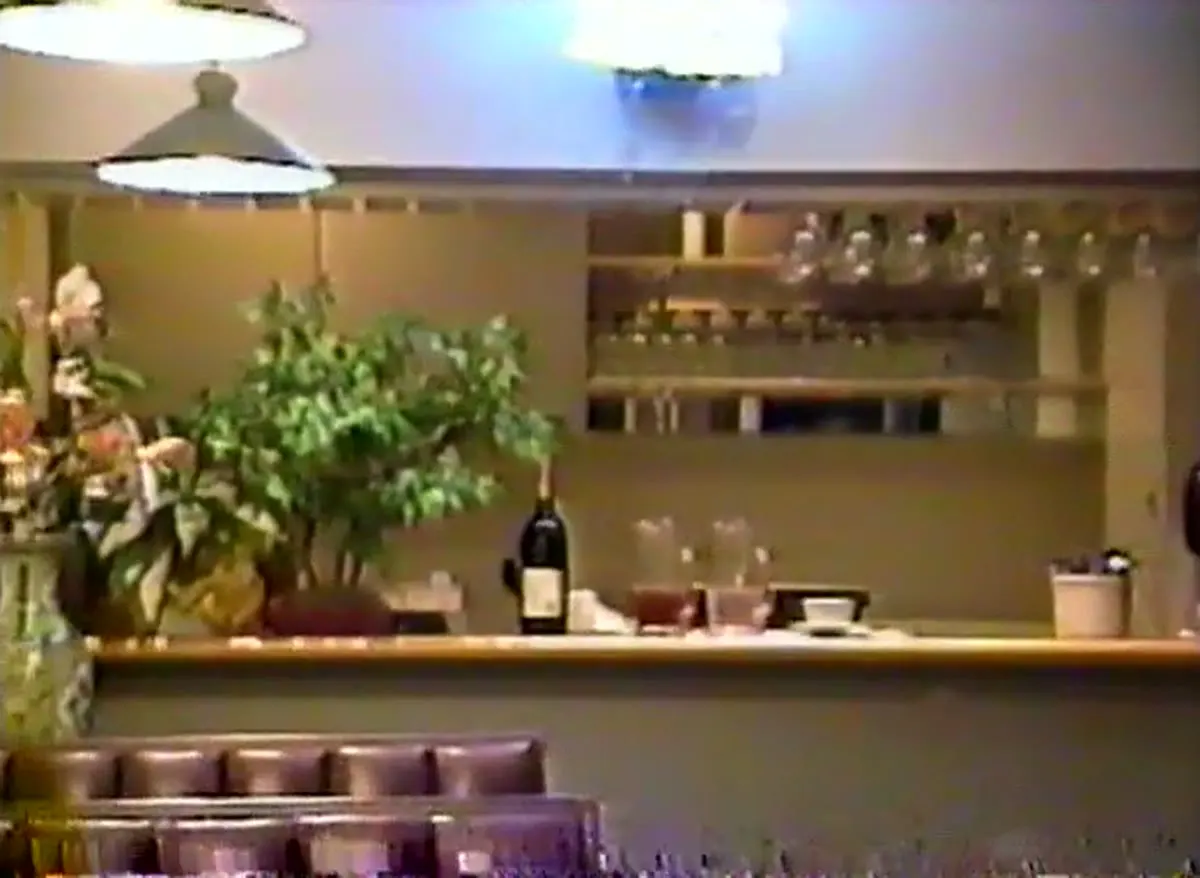 The bar with glass racks and a neon sign, 1989